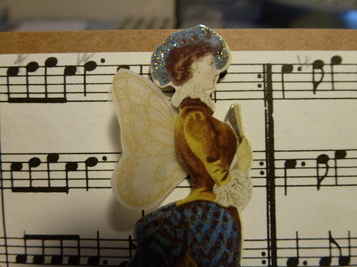 Detail of part of card showing the gold ink stamped wings behind the Edwardian lady.